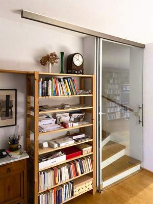 Schiebetür aus Glas vor Treppenaufgang